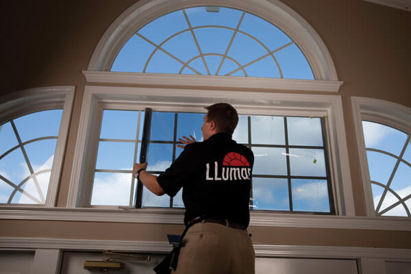 worker installing llumar window film